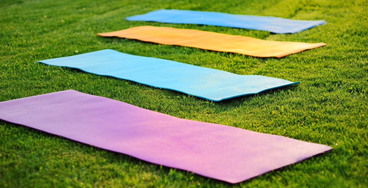 Yogamatten in het gras van een park tijdens een les over veerkracht en yoga